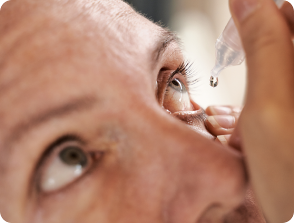A person putting ROCKLATAN drops in their eye